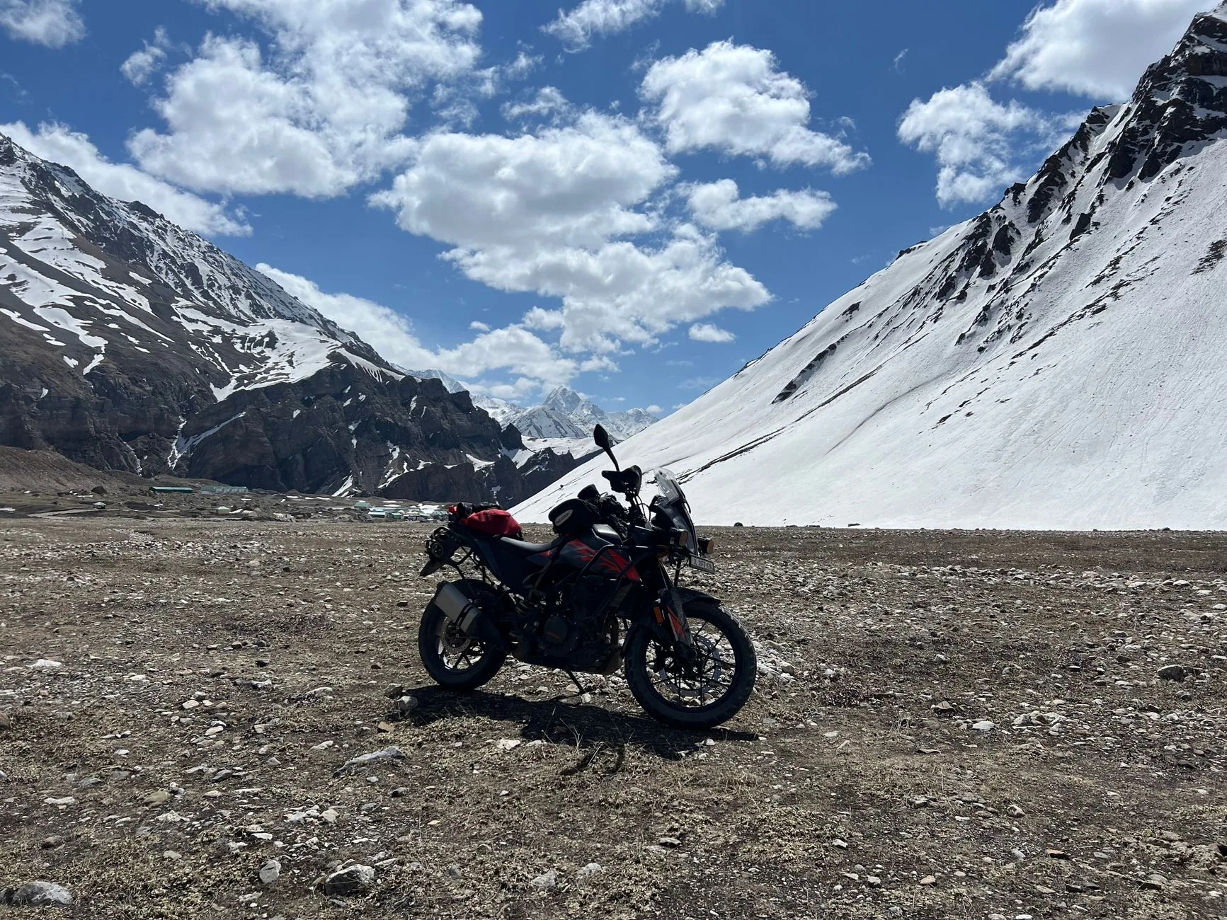 Dusty rider on 990 KTM Adventure bike traversing rugged off-road terrain.