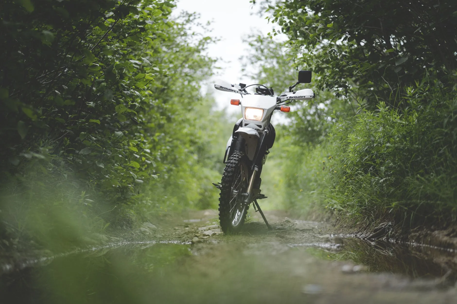 Adventure rider in leather jacket, dusty terrain, Cardo Discount Codes.