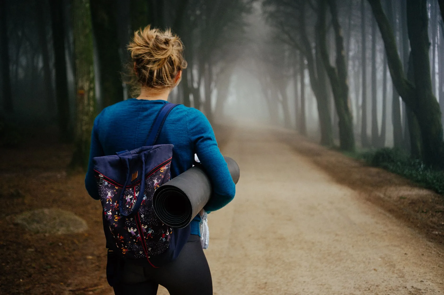Woman in brown riding suit on Himalayan trail, misty mountains, adventure riding.